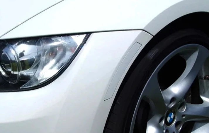 A close up view of AUTOTECKNIC PAINTED FRONT BUMPER REFLECTORS - BMW E90 3-SERIES | E92 3-SERIES 2005-2013 fitted on a white car