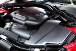 Carbon fiber cold air intake system installed in engine bay with curved intake tubes and engine cover visible - Eventuri cold air intake for BMW M3