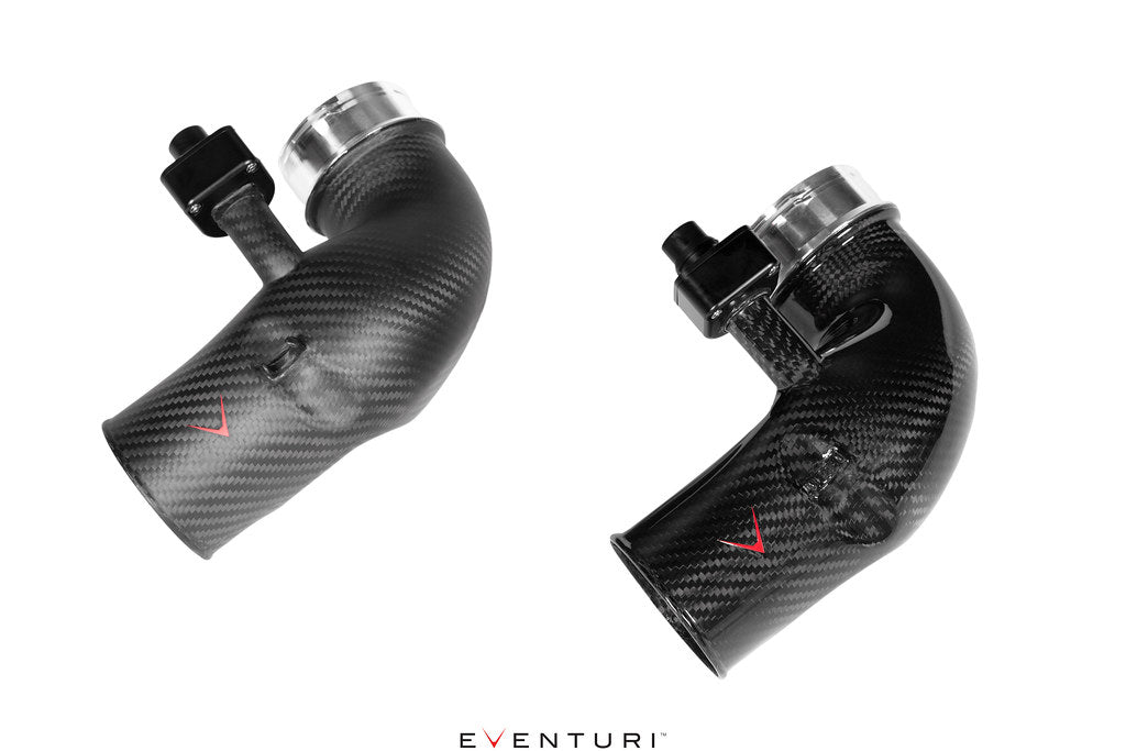 Two curved carbon fiber inlet pipes with polished metal couplers and black fittings on white background - Eventuri turbo inlet for BMW G90 G99 M5