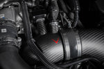Carbon fiber turbo inlet pipe with aluminum coupling band installed in engine bay with red arrow pointing to component - Eventuri turbo inlet for BMW G90 G99 M5