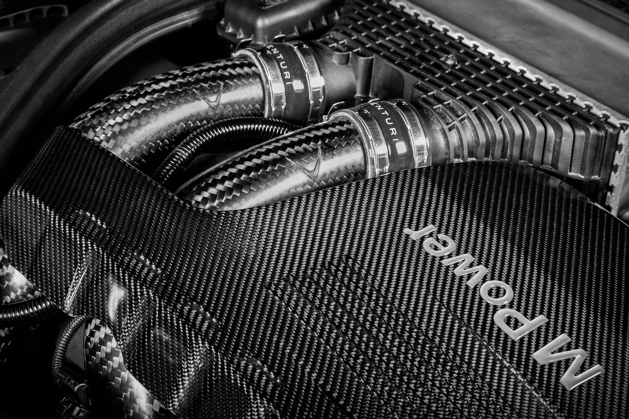 Carbon fiber charge pipes with metal clamps installed in BMW M3 engine bay - Eventuri charge pipes for BMW M3