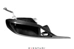 Black carbon fiber headlamp duct with curved aerodynamic shape and aluminum mounting brackets on white background - Eventuri headlamp duct for Toyota Supra