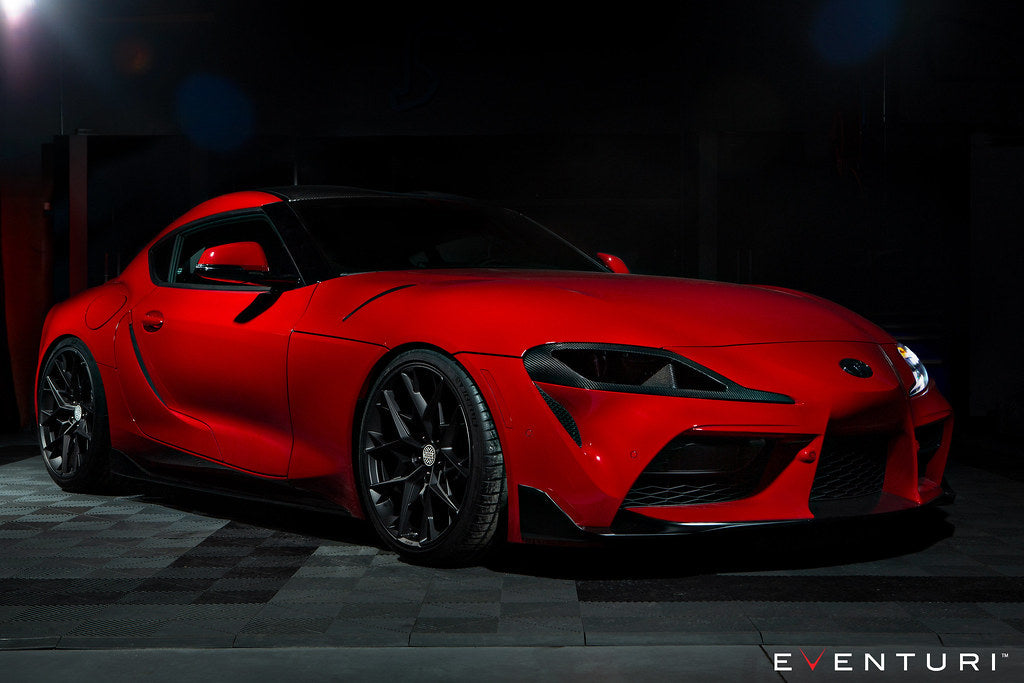Red Toyota Supra with black carbon fiber headlamp ducts visible in the front bumper air intakes - Eventuri headlamp duct for Toyota Supra