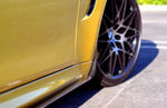 A side view of AUTOTECKNIC CARBON FIBER FRONT SPLASH GUARDS - BMW F80 M3 | F82/ F83 M4 2014+ fitted on a yellow car