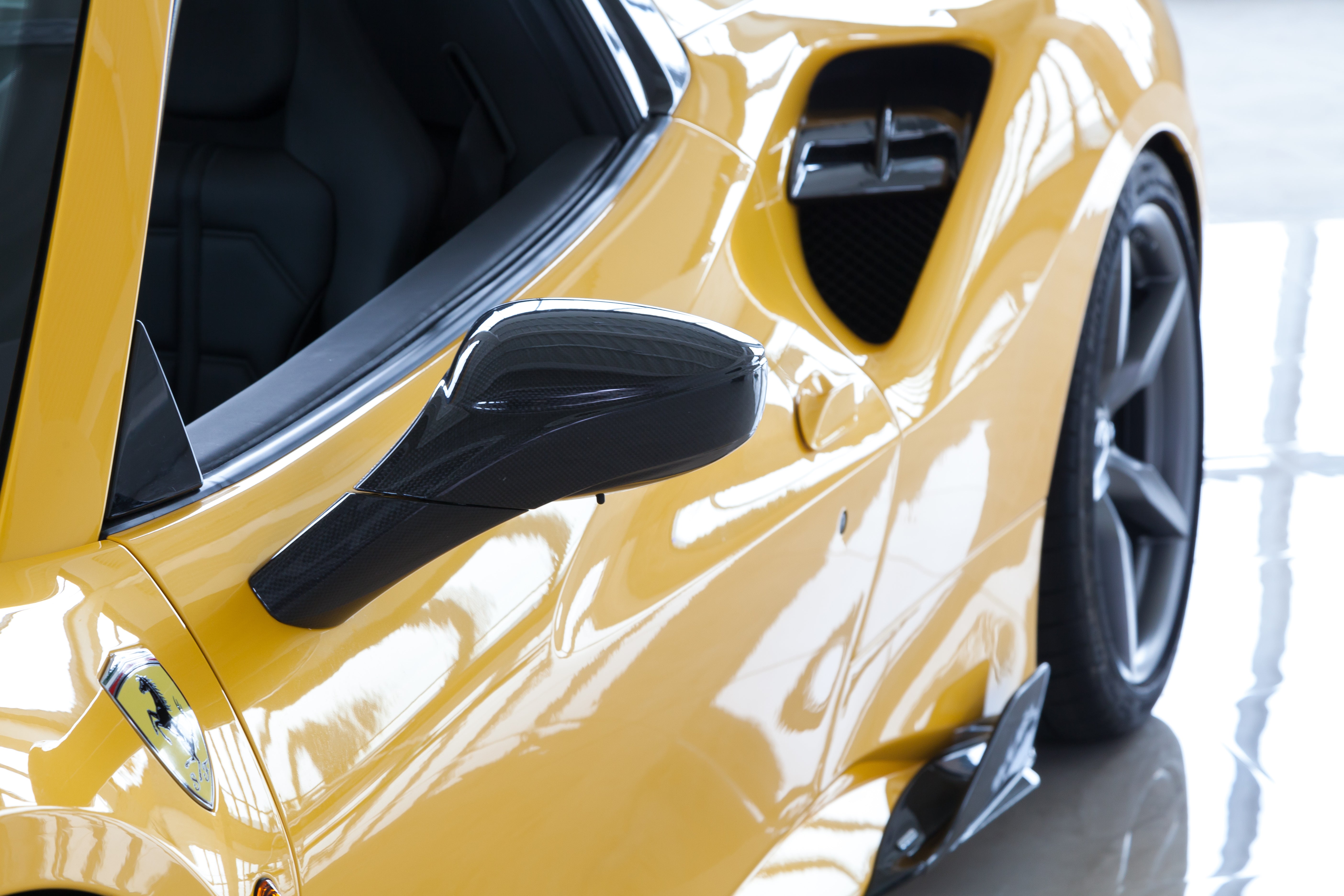 Capristo carbon fiber mirror on a yellow Ferrari 488, side view