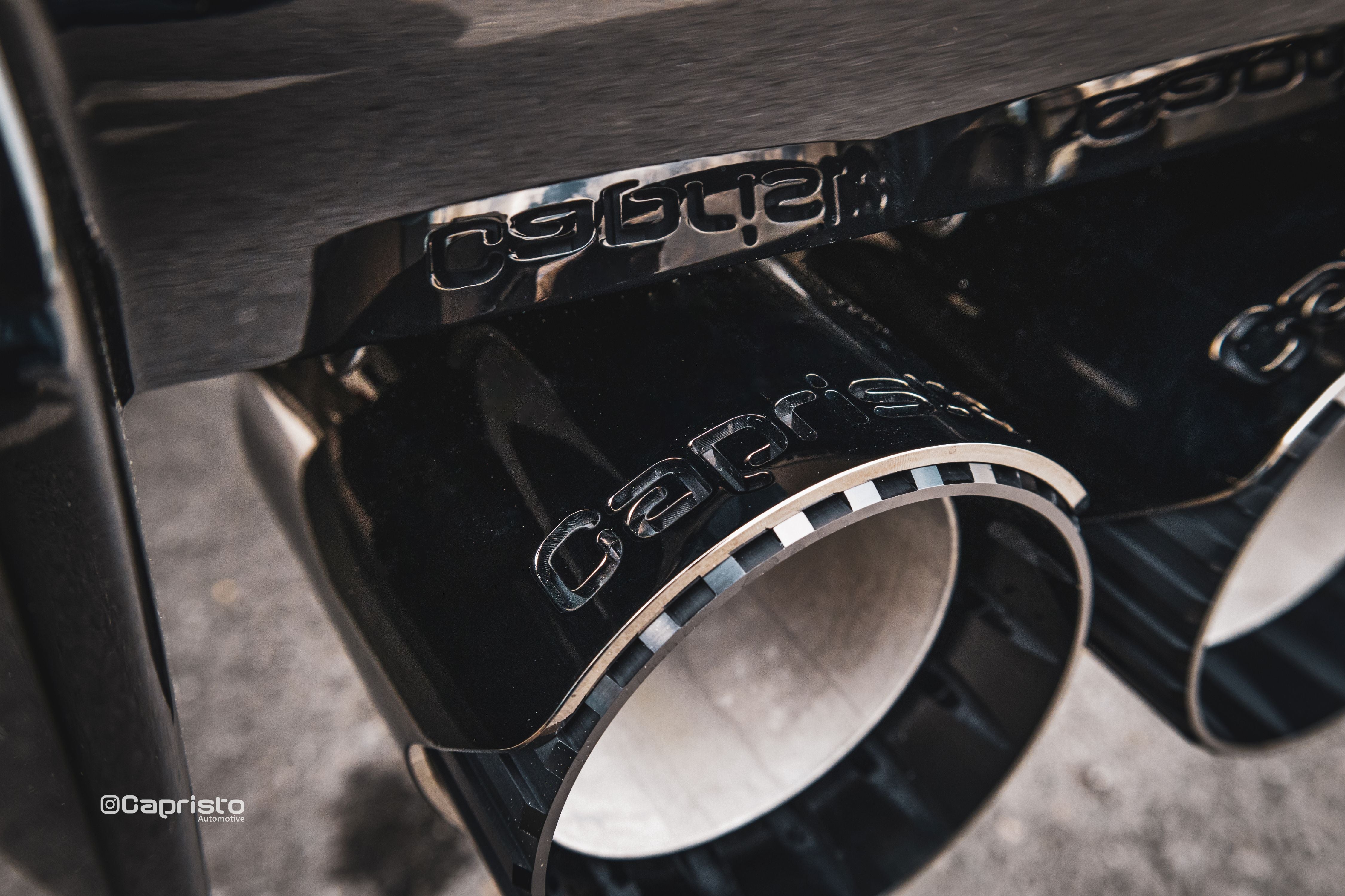 Close-up of Capristo black Wicrom tips with logo on BMW M3