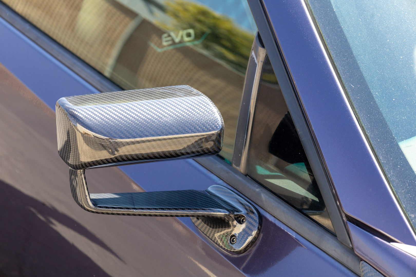 Carbon fiber aerodynamic side mirror with clear finish mounted on blue sports car door - APR Performance aero mirror for Scion FRS BRZ GT-86