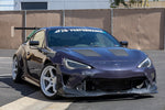 Black carbon fiber aerodynamic side mirrors mounted on dark blue sports car in parking lot setting - APR Performance aero mirror for Scion FRS BRZ GT-86