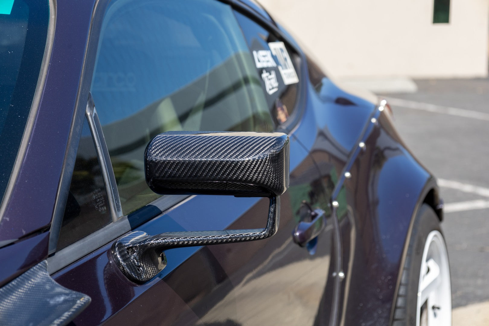 Black carbon fiber side mirror with aerodynamic housing and mounting arm installed on blue sports car - APR Performance aero mirror for Scion FRS BRZ GT-86