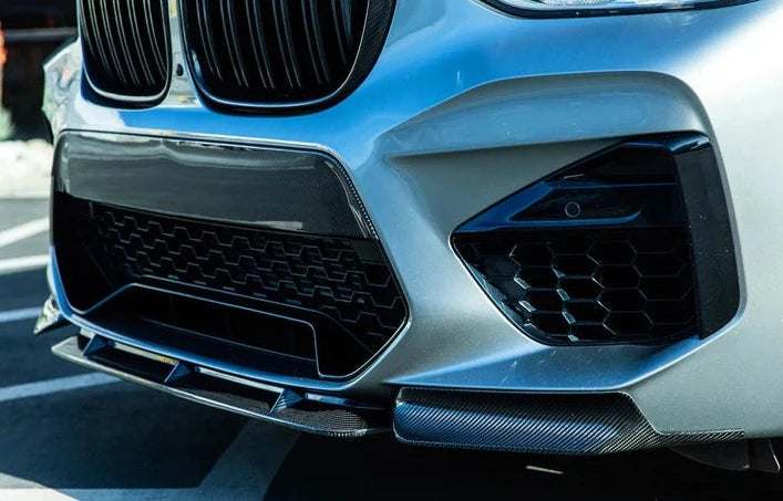 A close up view of a grey car fitted with AUTOTECKNIC DRY CARBON PERFORMANTE AERO SPLITTER & CENTER LIP SET - BMW F97 X3M | F98 X4M 2019+