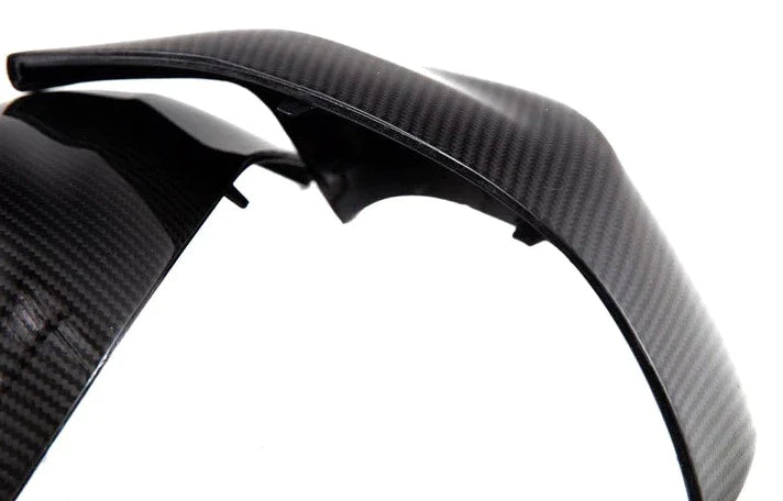 A close up view of AUTOTECKNIC REPLACEMENT DRY CARBON MIRROR COVERS - BMW F97 X3M | F98 X4M 2019+ with white background