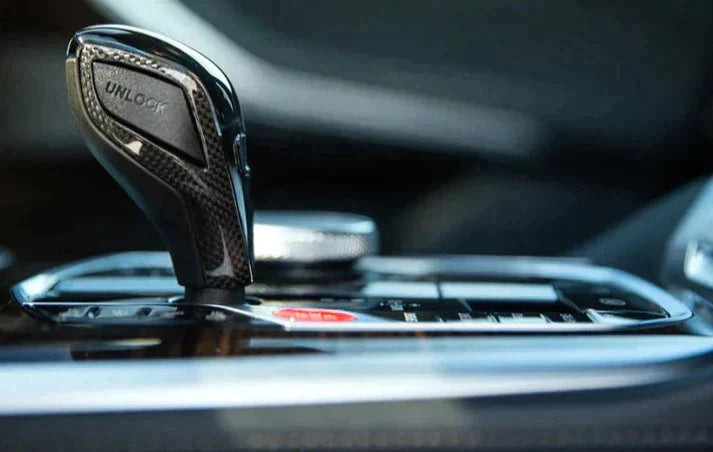 A close up view of AUTOTECKNIC CARBON FIBER GEAR SELECTOR SIDE TRIMS for BMW models fitted in a car