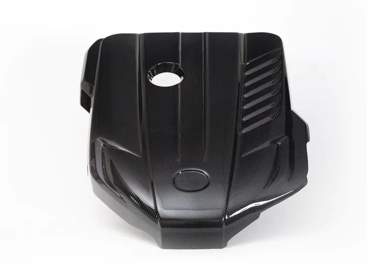 A front view of AUTOTECKNIC CARBON FIBER ENGINE COVER - TOYOTA A90 SUPRA 2020+ with white background