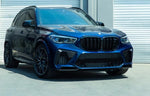 A front wide view of blue car fitted with AUTOTECKNIC PERFORMANCE DRY CARBON BUMPER TRIM SET - BMW F95 X5M Pre-LCI 2019-2021