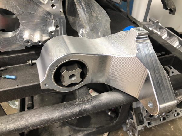 A side view of RK Autowerks F1X M5 & M6 BILLET DIFFERENTIAL MOUNT on a black surface