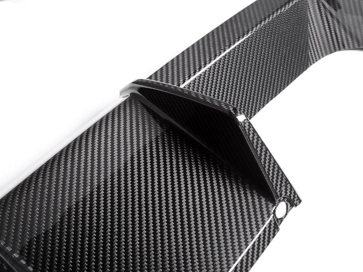 A close up view of AUTOTECKNIC DRY CARBON MOTORSPORT REAR DIFFUSER - BMW G80 M3 | G82/ G83 M4 2021+ with white background