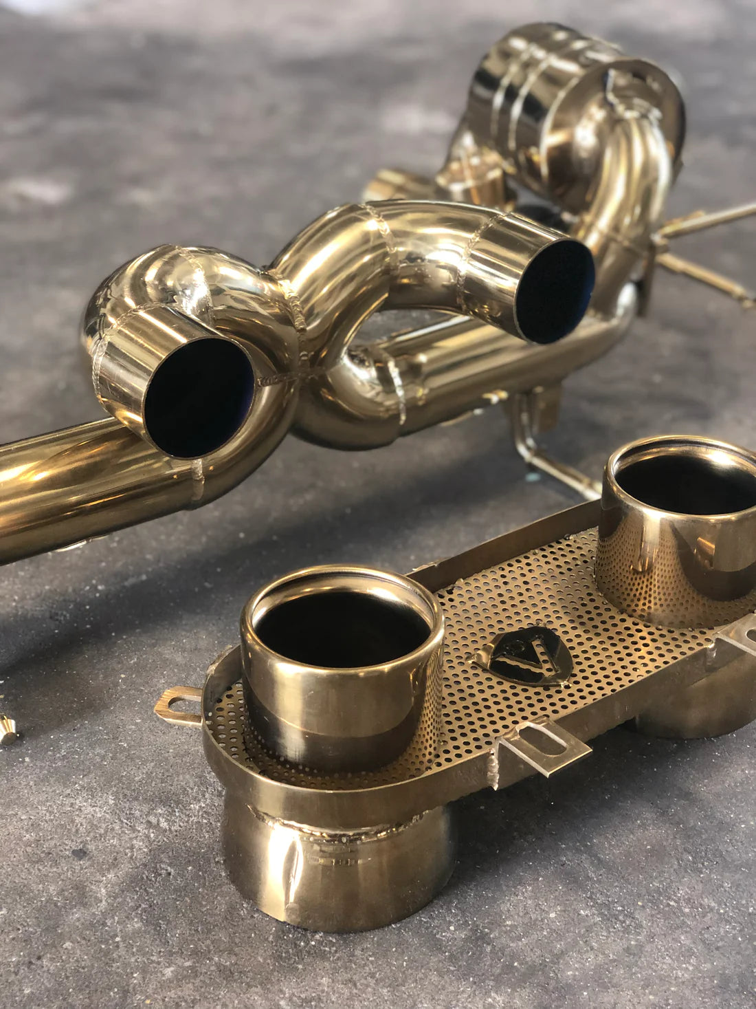 A close up view of Valvetronic Designs Valved Sport Exhaust System on the ground (for Ferrari 458 Italia).