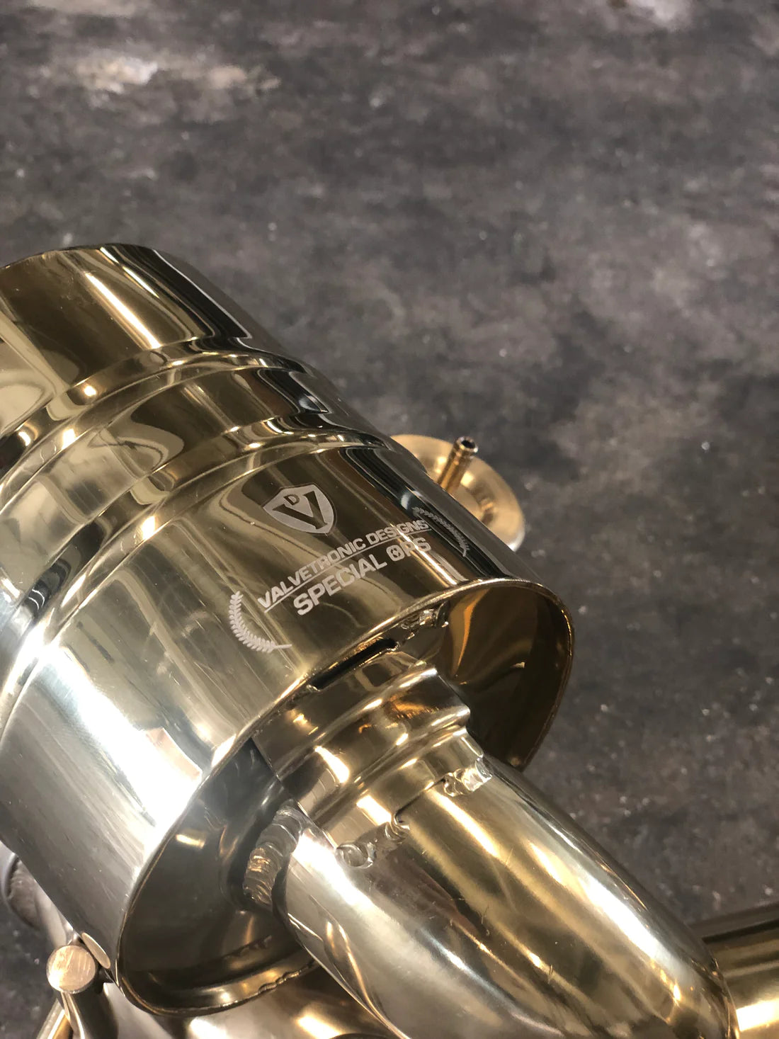 A close up view of Valvetronic Designs Valved Sport Exhaust System's muffler on the ground (for Ferrari 458 Italia).