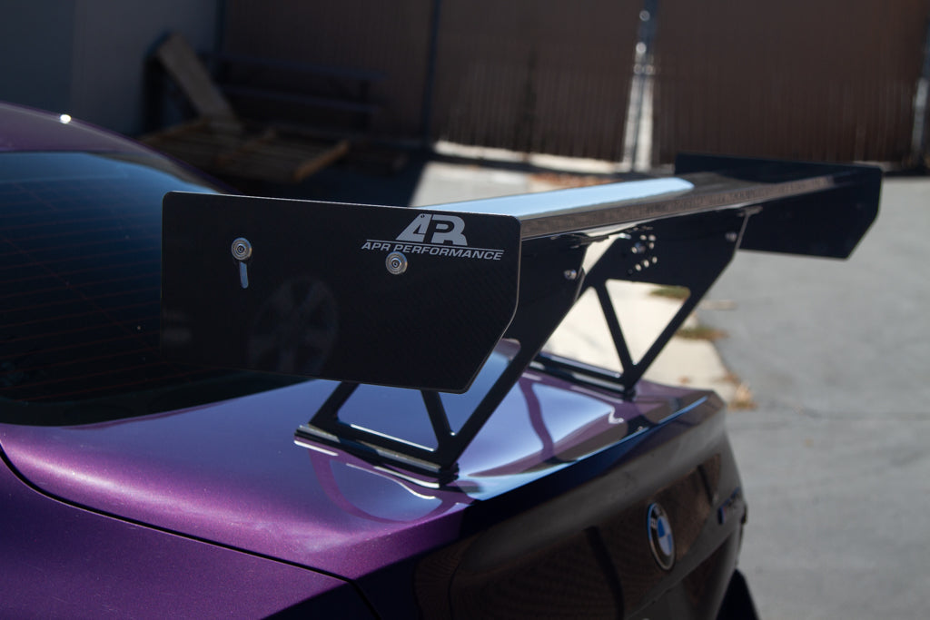 Black carbon fiber rear wing with aluminum uprights and endplates mounted on purple BMW trunk lid - APR Performance wing for BMW G42 M240i G87 M2