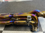 A view of a part of Valvetronic Designs Valved Sport Exhaust System (for Audi R8 V10 / Lamborghini HuracanF1) on the ground with black and white and tiles.