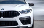 A close up view of a white BMW fitted with AUTOTECKNIC PERFORMANCE DRY CARBON SPLITTER SET - BMW F9X M8 2019+