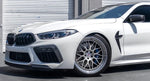 A side view of a white car fitted with AUTOTECKNIC PERFORMANCE DRY CARBON BUMPER TRIM SET - BMW F9X M8 2019+