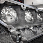 A close up view of RK Autowerks S63TU/4 PORTED & POLISHED CNC HEADS on a black table