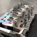 A side close up view of RK Autowerks S63TU/4 PORTED & POLISHED CNC HEADS on a black table