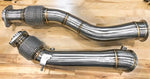 A top view of RK Autowerks F97 F98 X3M X4M CATLESS DOWNPIPES on a wooden floor