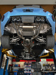A view of Valvetronic Designs Valved Sport Exhaust System fitted on a lifted blue car from beneath (for BMW G87 M2).