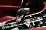 A close up view of AUTOTECKNIC CARBON FIBER EXCLUSIVE DESIGN SHIFT LEVER for Porsche Models fitted in a car with red interior