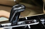 A close up view of AUTOTECKNIC CARBON FIBER GEAR SELECTOR COVER - PORSCHE 9Y0/9Y0.2 CAYENNE 2019+ fitted in a car