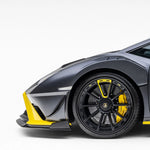 A side wide view of a car fitted with Vorsteiner Aero Canards Carbon Fiber for Lamborghini Huracan STO 2021-2025 on a white background