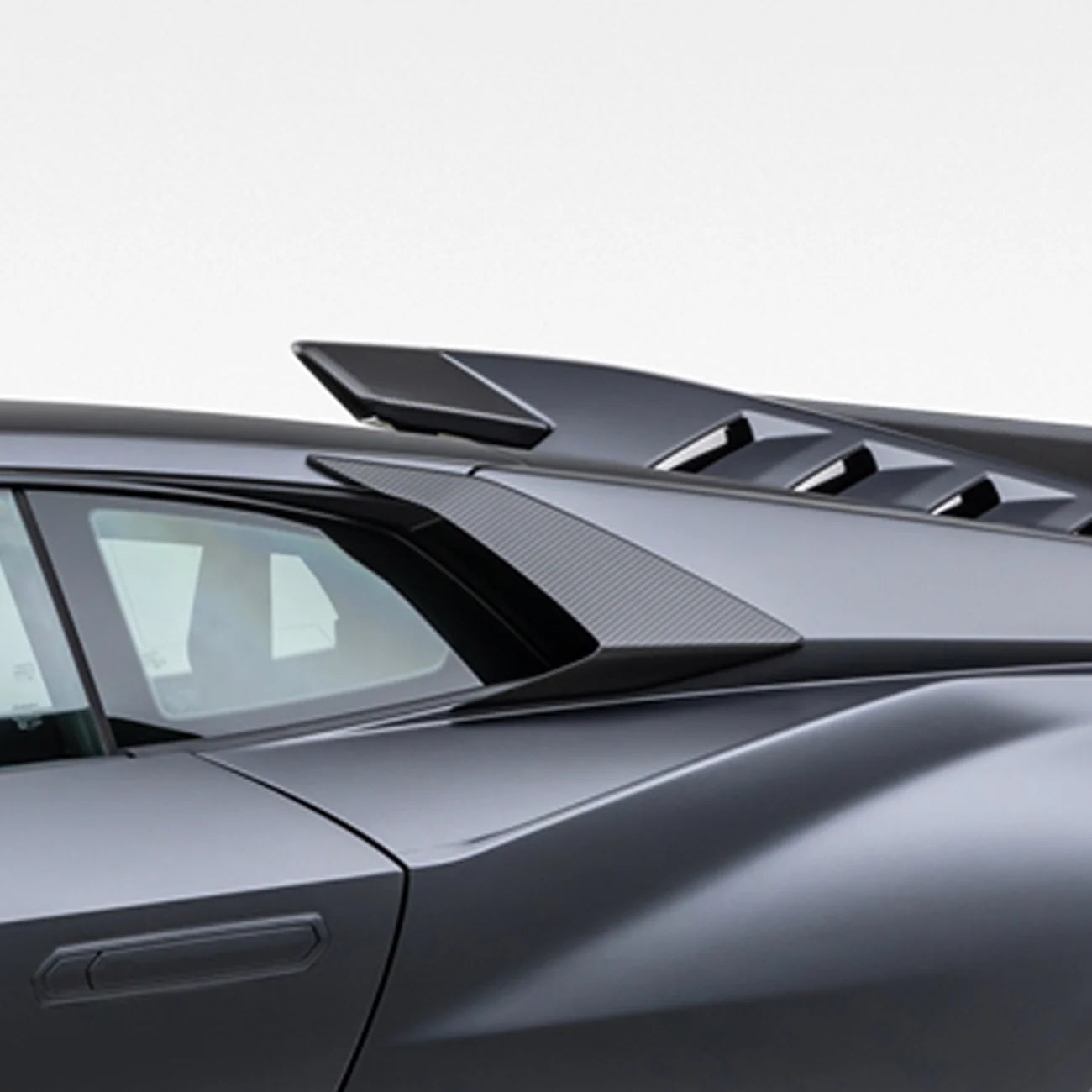 A side close up view of a car fitted with Vorsteiner Aero Side Intakes Carbon Fiber for Lamborghini Huracan STO 2021-2025 with white background