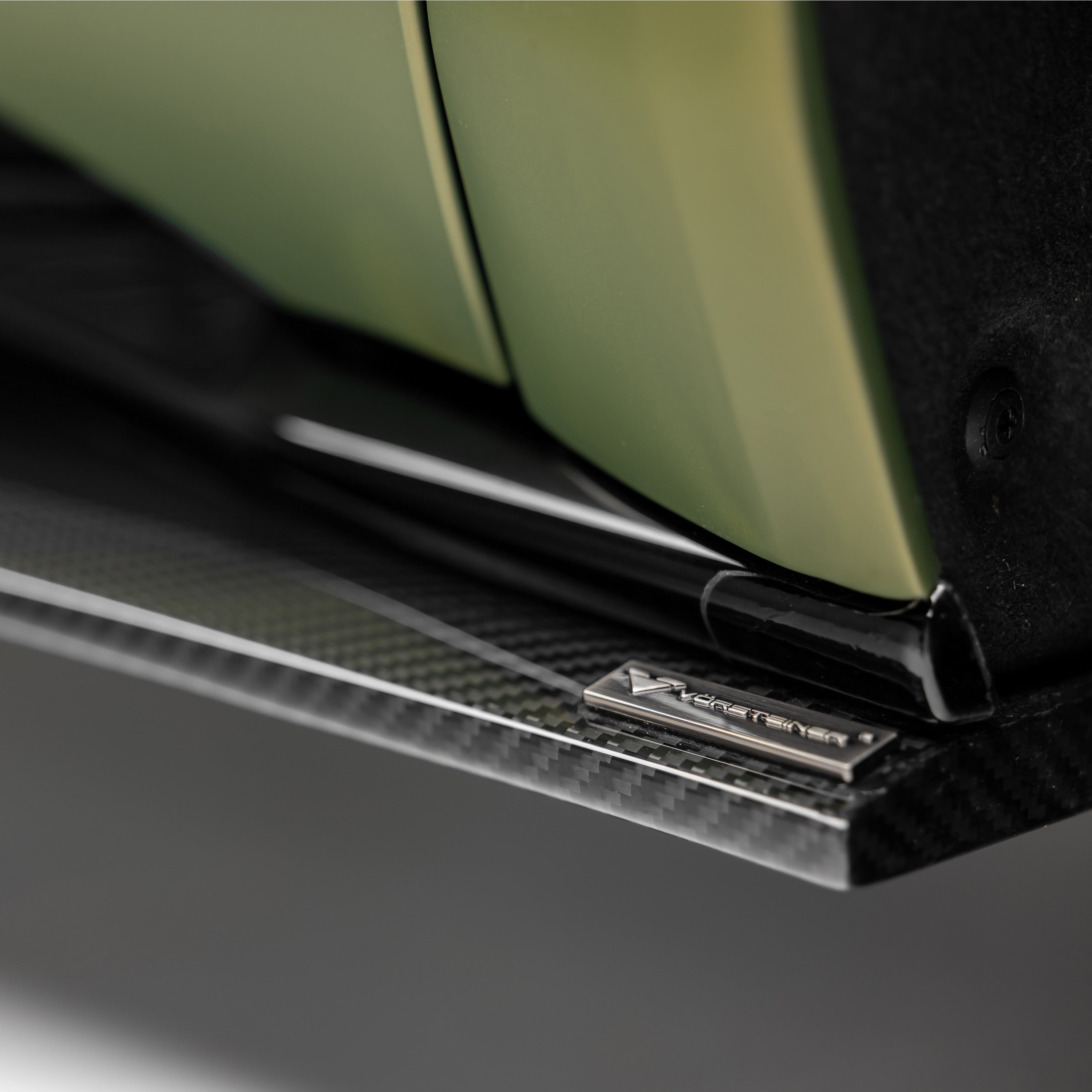 Gloss carbon Emira side skirt with logo, macro detail