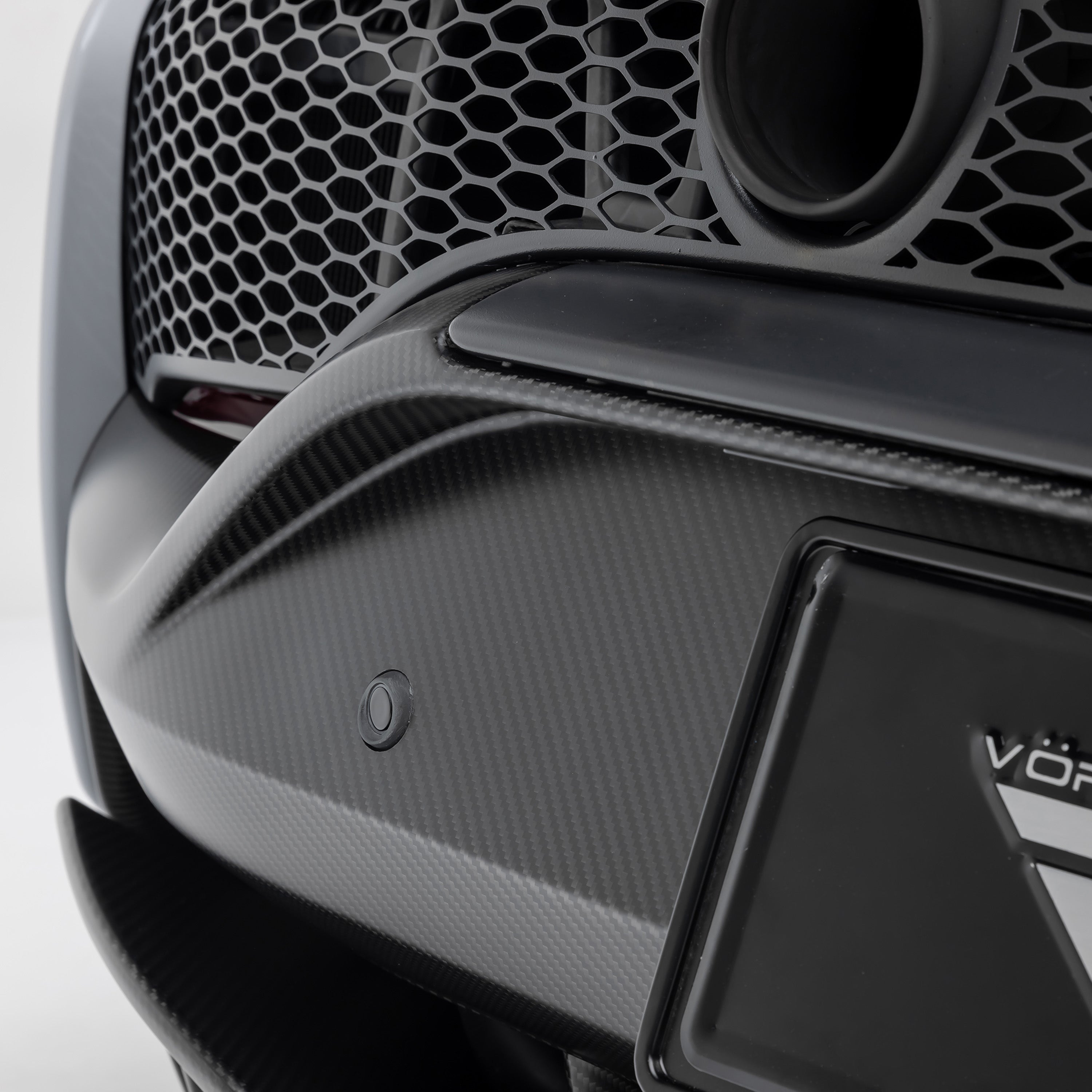 Carbon rear bumper corner and mesh on Artura, macro