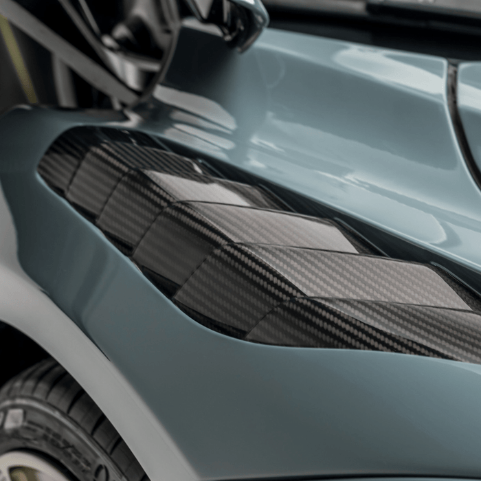 A close up view of Vorsteiner Silverstone Edition Glossy Carbon Fiber PP 2x2 Aero Front Fenders w/ Integrated Vents McLaren 720S 2017+ fitted in a car