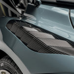 A close up view of Vorsteiner Silverstone Edition Glossy Carbon Fiber PP 2x2 Aero Front Fenders w/ Integrated Vents McLaren 720S 2017+ fitted in a car