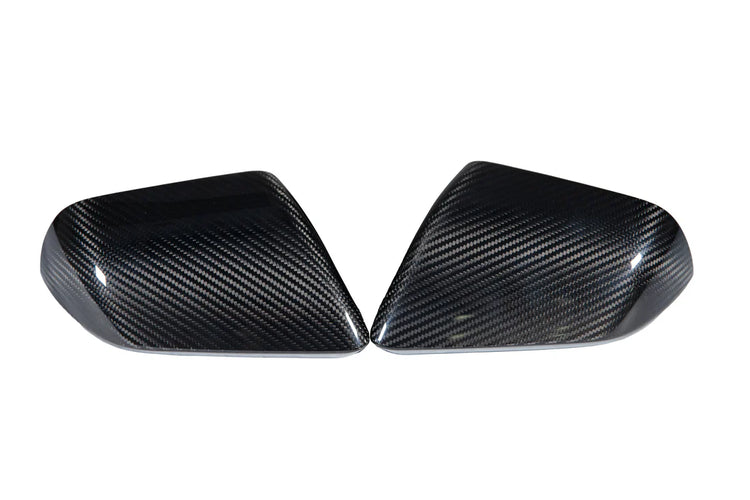 A front view of APR Performance Carbon Fiber Replacement Mirrors Ford Mustang S550 / S650 / GT350 / GT500 2015-2025 without turn signals behind a white background