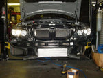 A front view of Evolution Racewerks Competition Series Front Mount Intercooler (FMIC) Kit for BMW N54/N55 135i/335i/1M fitted on a lifted car