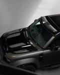 A top wide view of Urban Automotive Octa Limited Edition Forged Carbon Vented Hood for Land Rover Defender OCTA 2025 fitted on a black car