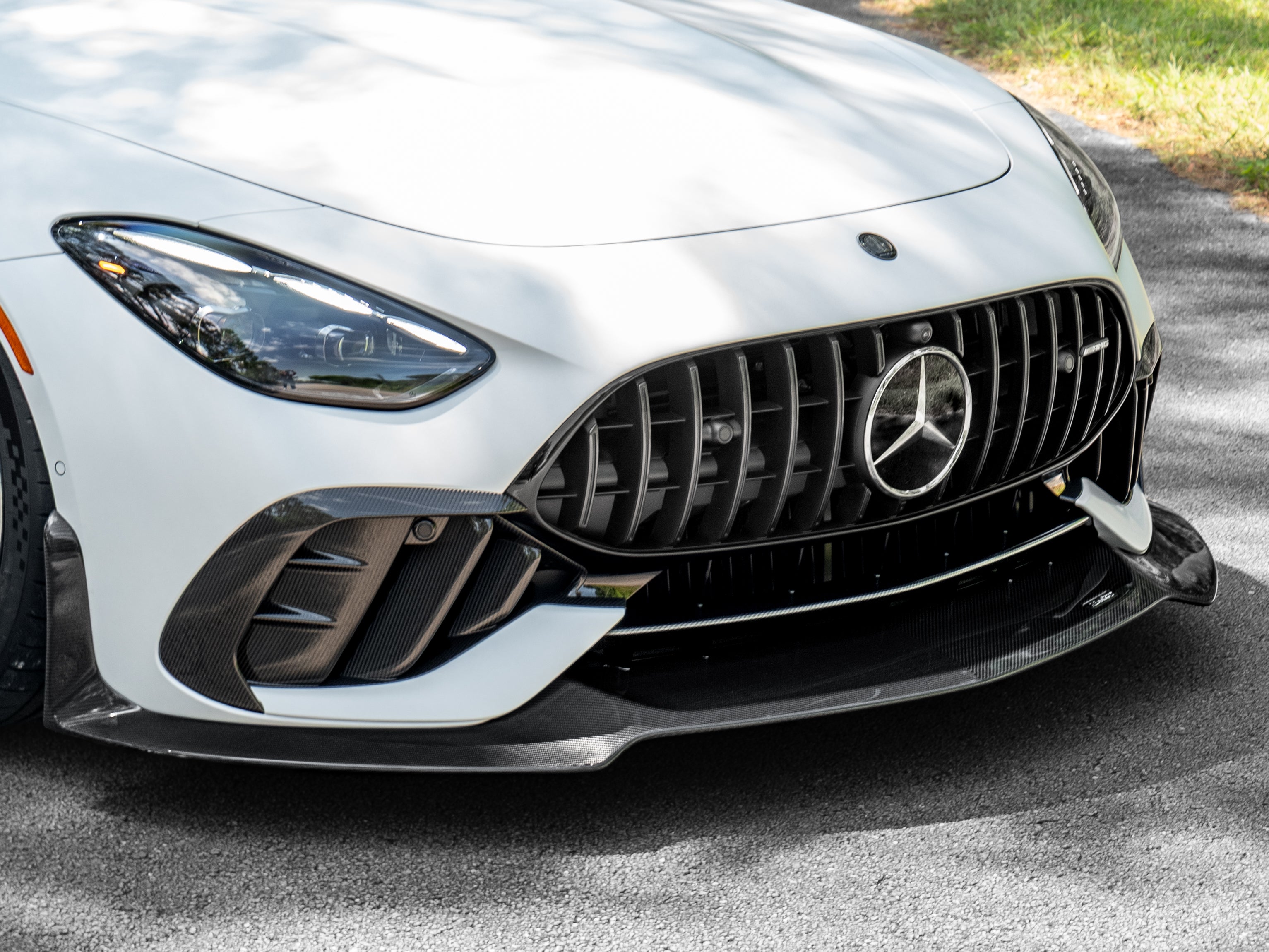 Front corner of a white AMG GT 63 showing the RennTech splitter under the bumper intake