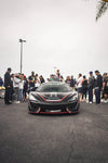 Black McLaren 570S front three-quarter with the complete aero kit at a car meet