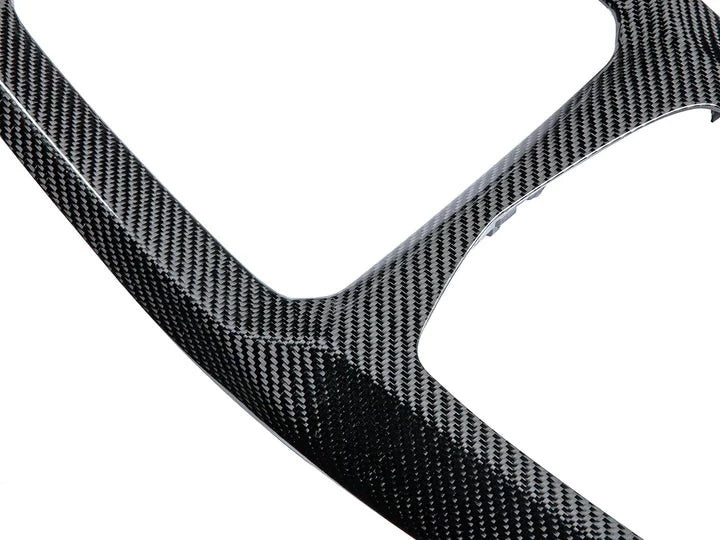 A very close up view of AUTOTECKNIC CARBON FIBER CENTER CONSOLE - BMW F97 X3M | F98 X4M LCI 2021+ with white background