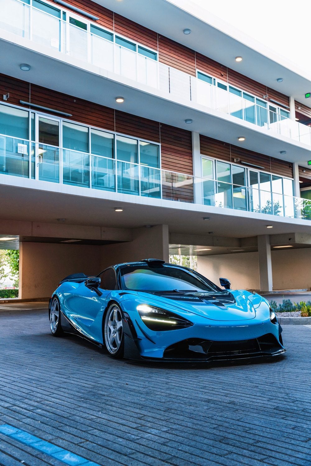 Blue McLaren 720S front three-quarter with carbon dive canards