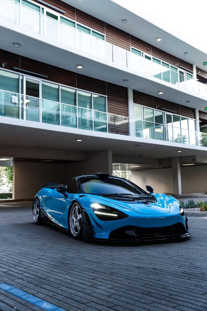 Blue McLaren 720S front three-quarter with carbon dive canards