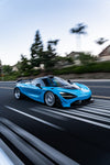 Blue McLaren 720S rolling shot with carbon dive canards