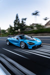 Blue McLaren 720S rolling shot with carbon dive canards