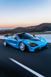 Blue McLaren 720S front three-quarter with the V2 complete aero kit on the road