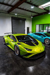 Lime green Lamborghini Huracan Evo front three-quarter with carbon race hood in a garage